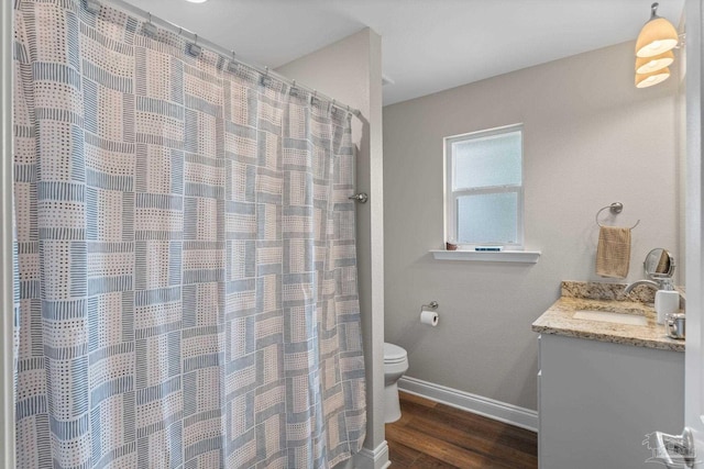 bathroom featuring baseboards, vanity, toilet, and wood finished floors
