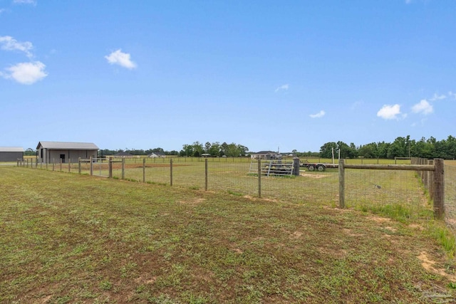 view of yard with fence and a rural view