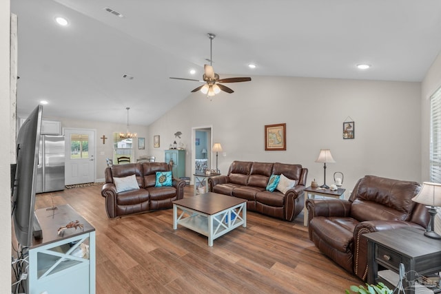 living room with visible vents, lofted ceiling, recessed lighting, light wood finished floors, and ceiling fan with notable chandelier