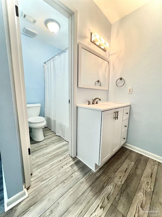 1100 Shoreline Dr Unit 207, Gulf Breeze, FL 32561 - full bathroom featuring wood finished floors, toilet, vanity, a shower with shower curtain, and baseboards