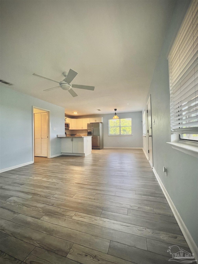 1100 Shoreline Dr Unit 207, Gulf Breeze, FL 32561 - unfurnished living room featuring wood finished floors, a ceiling fan, and baseboards