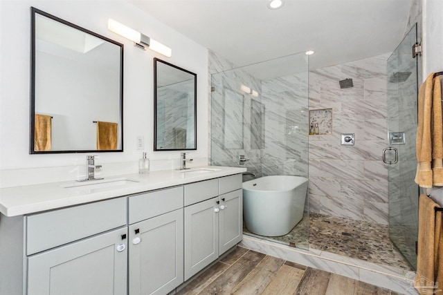 bathroom with plus walk in shower, vanity, and hardwood / wood-style flooring