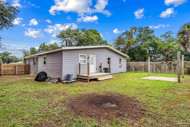 back of house with a lawn and a wooden deck