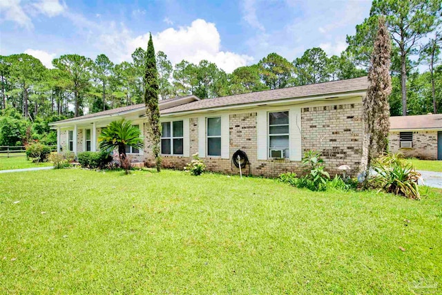 ranch-style home with cooling unit and a front lawn