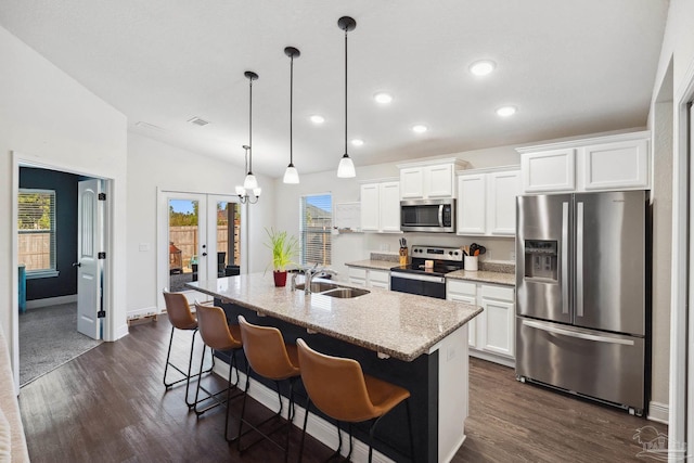 kitchen featuring plenty of natural light, white cabinetry, stainless steel appliances, and an island with sink