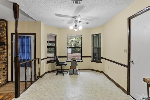 exercise room with baseboards, visible vents, a textured ceiling, and ceiling fan