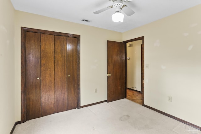 unfurnished bedroom featuring a closet, visible vents, light colored carpet, and baseboards