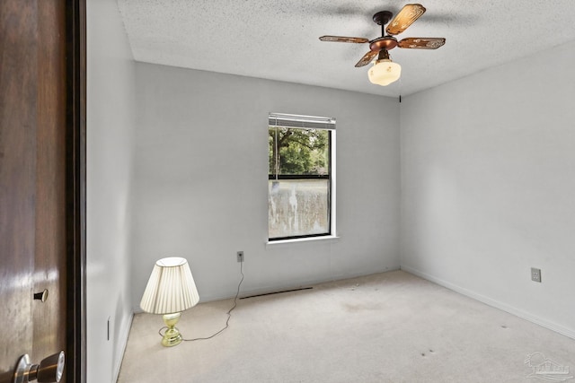 empty room featuring a ceiling fan, baseboards, carpet floors, and a textured ceiling