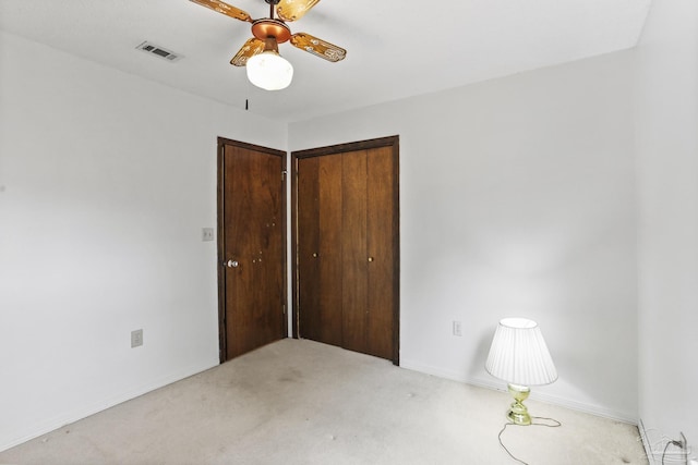 unfurnished bedroom with visible vents, a ceiling fan, a closet, baseboards, and light colored carpet