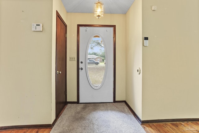 carpeted entrance foyer featuring baseboards