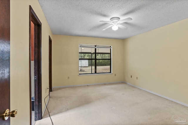 empty room featuring baseboards, a textured ceiling, and ceiling fan