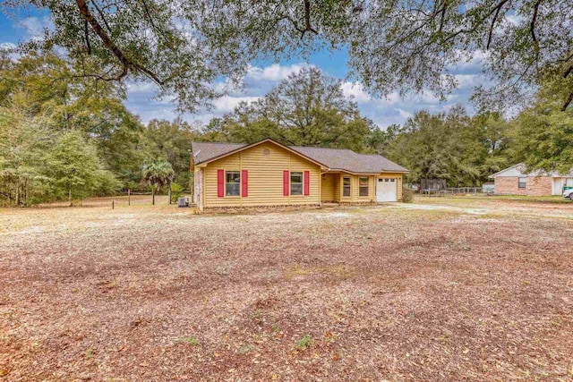 view of front of property with an attached garage, driveway, and fence