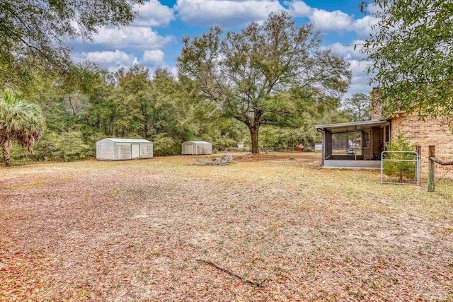 view of yard featuring a storage unit, an outdoor structure, and a sunroom