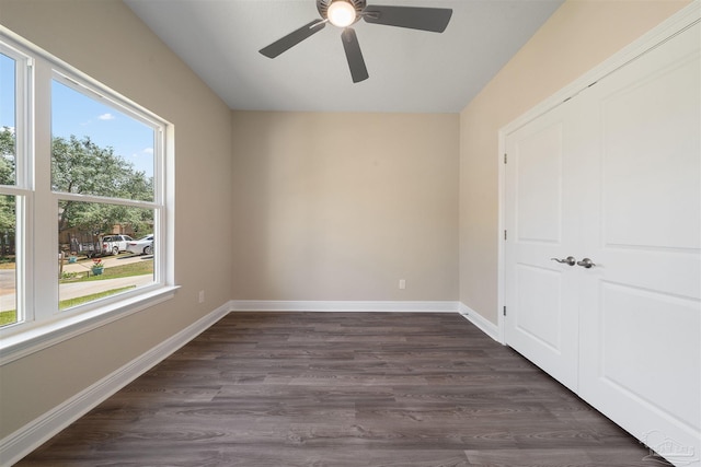 unfurnished bedroom featuring a closet, ceiling fan, and dark wood-type flooring