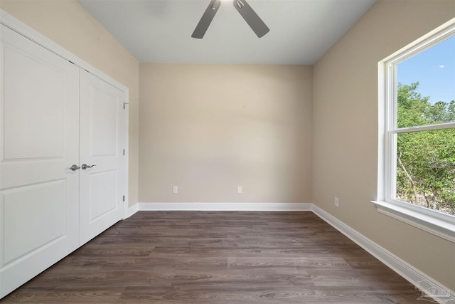 unfurnished bedroom with ceiling fan, a closet, and dark wood-type flooring