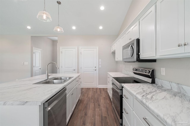 kitchen with stainless steel appliances, sink, decorative light fixtures, white cabinetry, and an island with sink