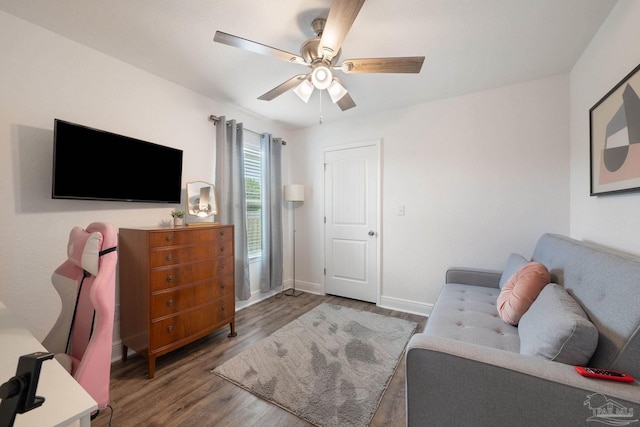 living room featuring baseboards, ceiling fan, and wood finished floors