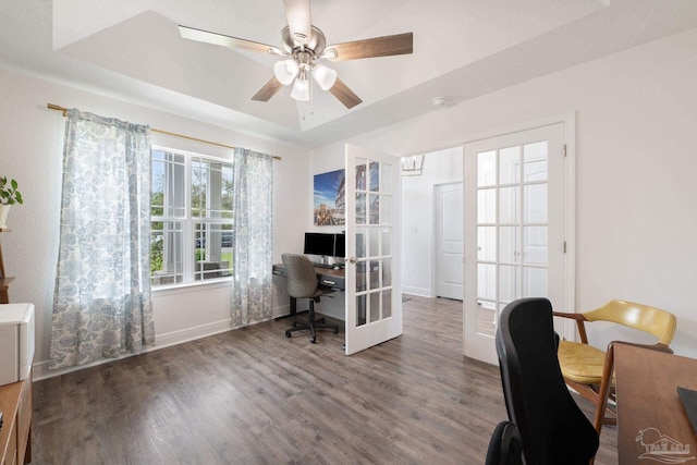 office space with baseboards, a ceiling fan, a raised ceiling, and wood finished floors