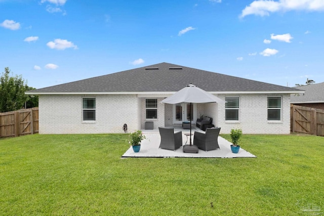 back of house featuring a fenced backyard, a patio, a lawn, and brick siding