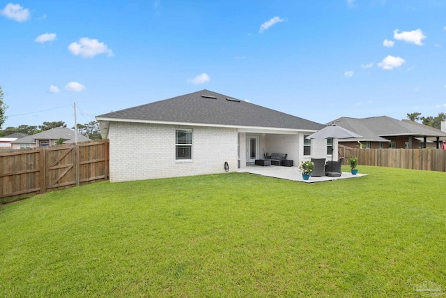 rear view of house featuring a fenced backyard, a yard, a patio area, and brick siding