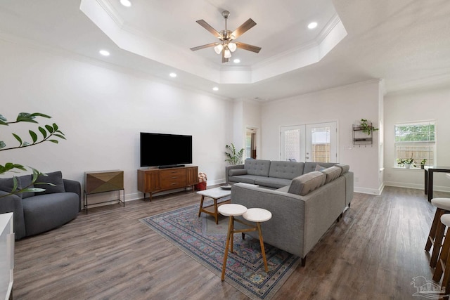living area with recessed lighting, ceiling fan, wood finished floors, and a raised ceiling