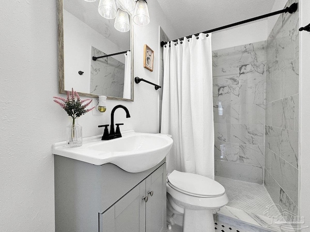 bathroom featuring a tile shower, vanity, and toilet