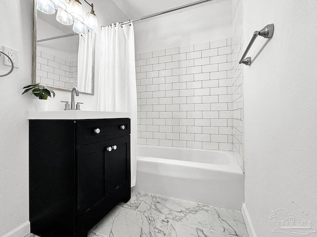 bathroom featuring marble finish floor, shower / bath combination with curtain, vanity, and baseboards