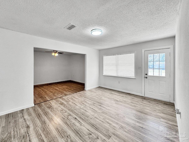 interior space with visible vents, ceiling fan, baseboards, and wood finished floors