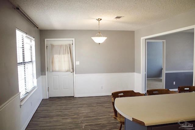 dining area with visible vents, dark wood-style floors, and a textured ceiling