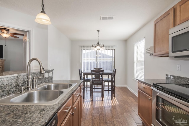 kitchen featuring sink, decorative light fixtures, appliances with stainless steel finishes, dark hardwood / wood-style floors, and ceiling fan with notable chandelier