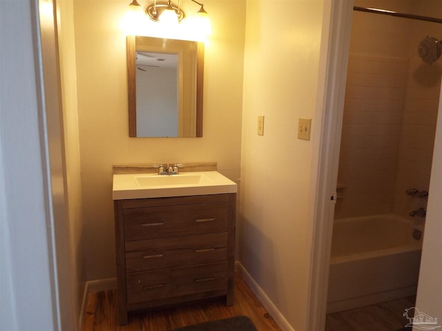 bathroom featuring hardwood / wood-style flooring, vanity, and tiled shower / bath