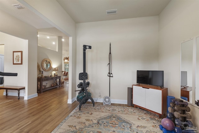 workout room featuring visible vents, baseboards, and wood finished floors