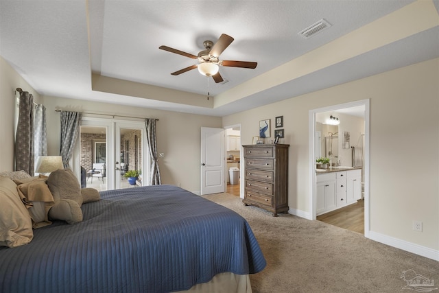 bedroom featuring a tray ceiling, visible vents, light carpet, access to outside, and baseboards