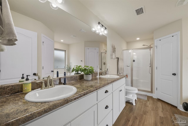 full bathroom with toilet, visible vents, a sink, and wood finished floors