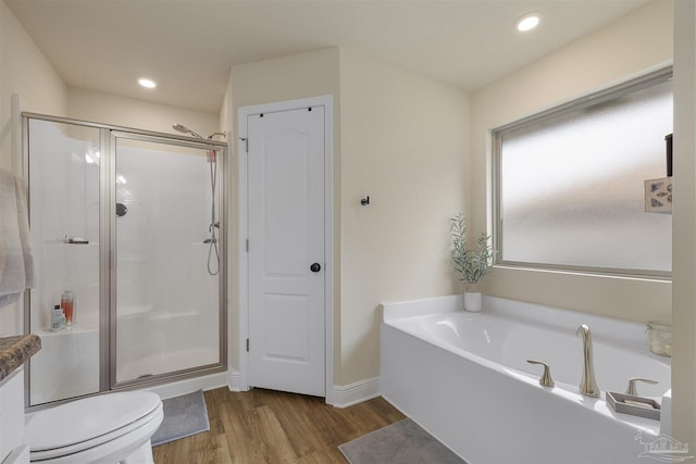 bathroom with recessed lighting, a shower stall, a bath, and wood finished floors