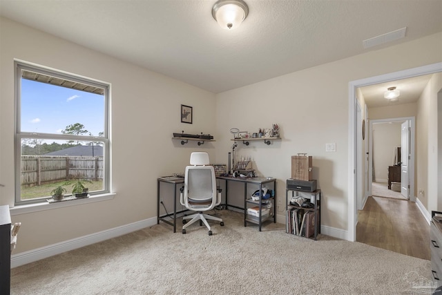 carpeted home office with visible vents and baseboards