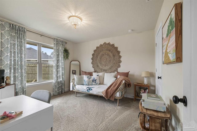 carpeted bedroom featuring a textured ceiling and baseboards