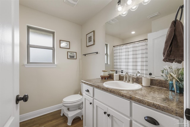 full bathroom with visible vents, vanity, baseboards, and wood finished floors