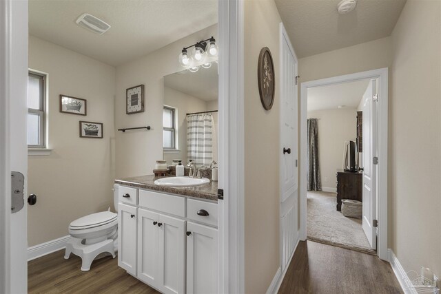 full bath featuring baseboards, vanity, toilet, and wood finished floors