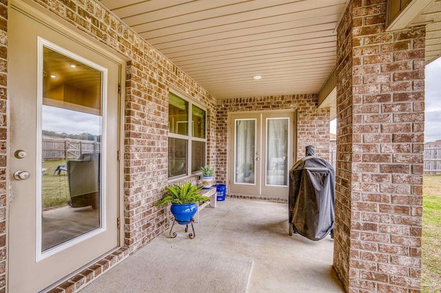 view of patio with french doors, fence, and grilling area