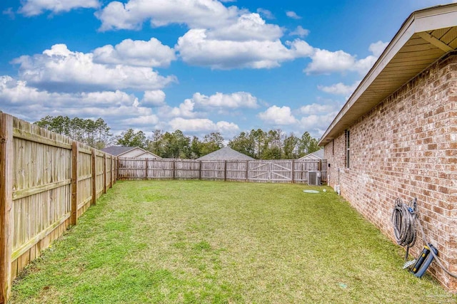 view of yard with central air condition unit and a fenced backyard