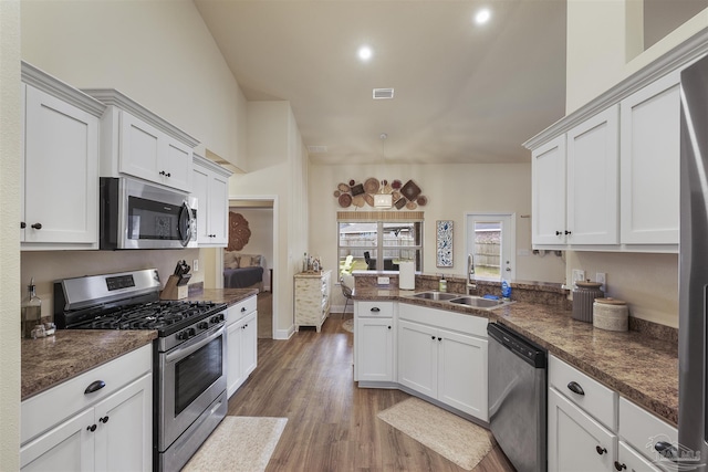 kitchen with visible vents, white cabinetry, stainless steel appliances, and a sink