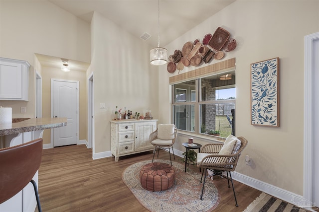 living area featuring dark wood finished floors, visible vents, and baseboards