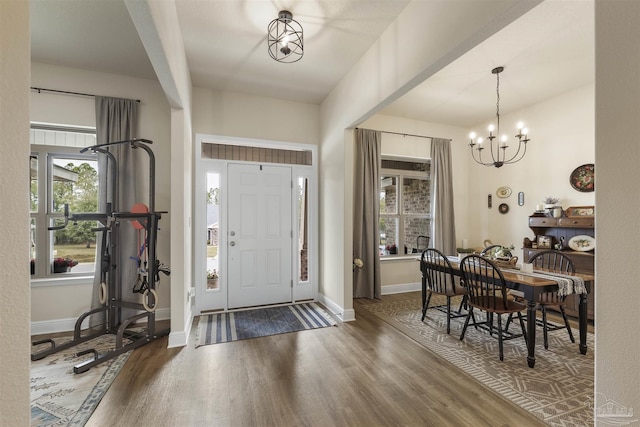 foyer entrance with baseboards, dark wood-style flooring, and a notable chandelier