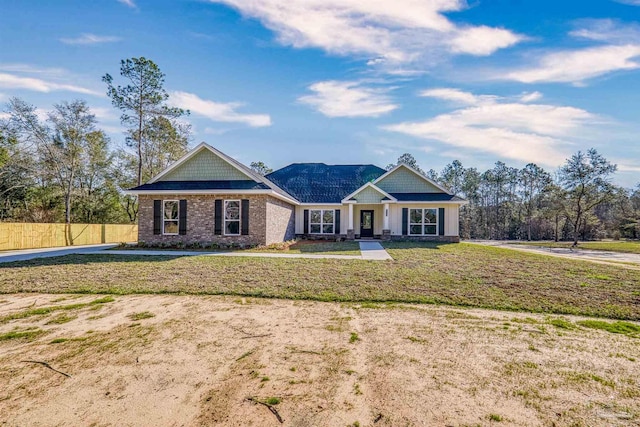 craftsman-style home with fence and a front lawn