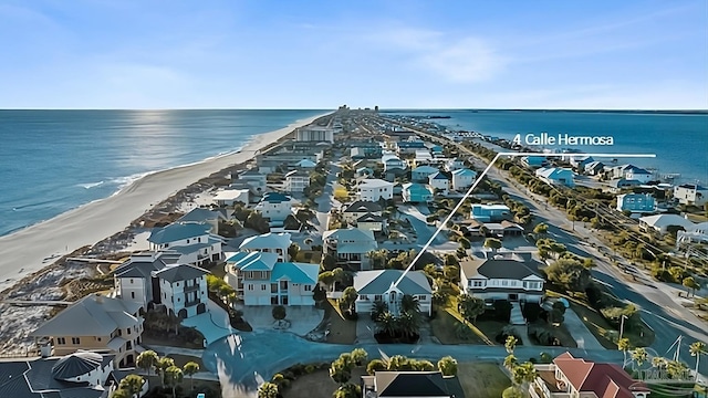 birds eye view of property with a water view and a beach view