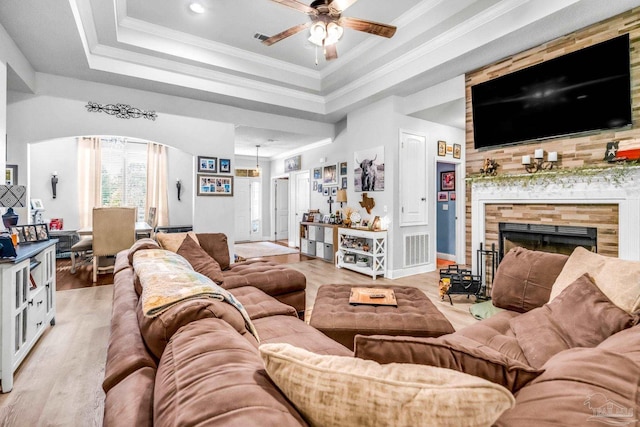 2704 Wildhurst Trl, Pace, FL 32571 - living room featuring a ceiling fan, arched walkways, light wood-type flooring, a fireplace with flush hearth, and ornamental molding