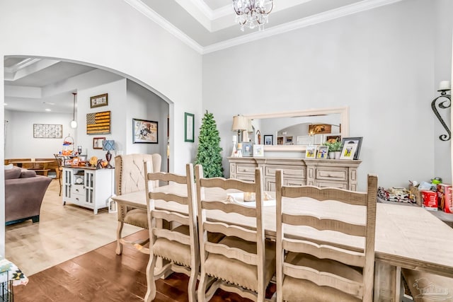 2704 Wildhurst Trl, Pace, FL 32571 - dining area featuring arched walkways, ornamental molding, wood finished floors, a chandelier, and a towering ceiling