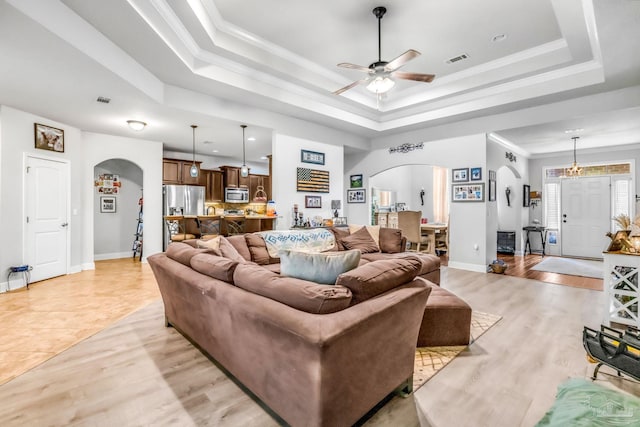 2704 Wildhurst Trl, Pace, FL 32571 - living room with arched walkways, a raised ceiling, a ceiling fan, and light wood-style floors
