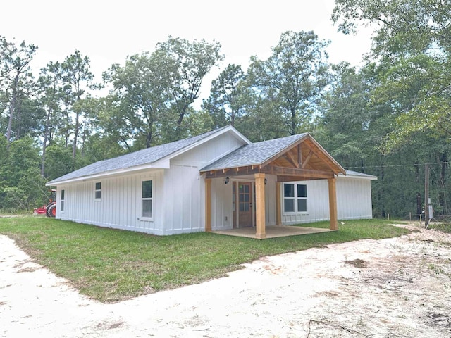 5661 Dupree Rd, Milton, FL 32570 - view of front of home featuring a front yard, roof with shingles, view of scattered trees, and board and batten siding